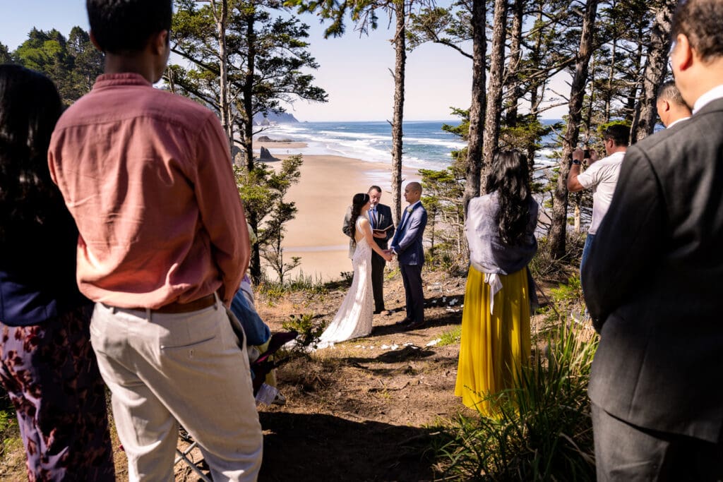 Eloping couple on rocky outcrop at Arch Cape, overlooking the ocean